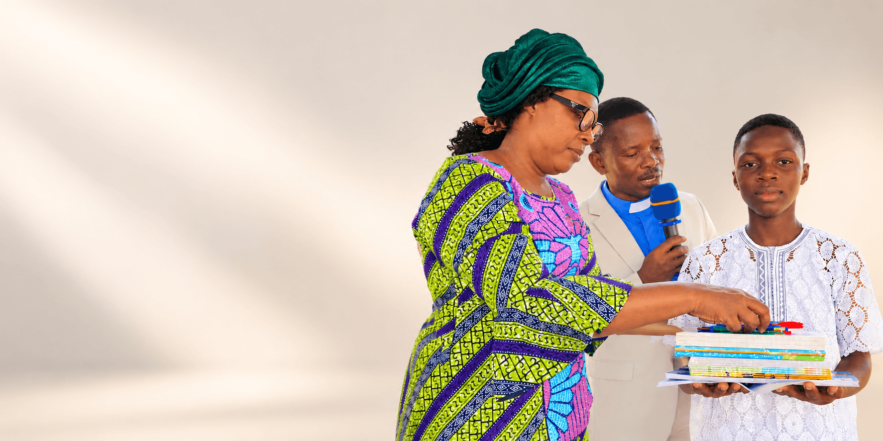 A student receiving books and school supplies from community leaders